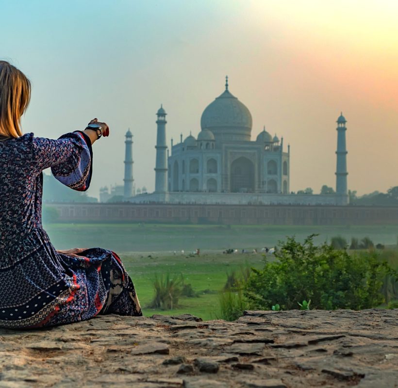 Beautiful girl points to Taj Mahal in Agra, Dehli. Wanderlust concept